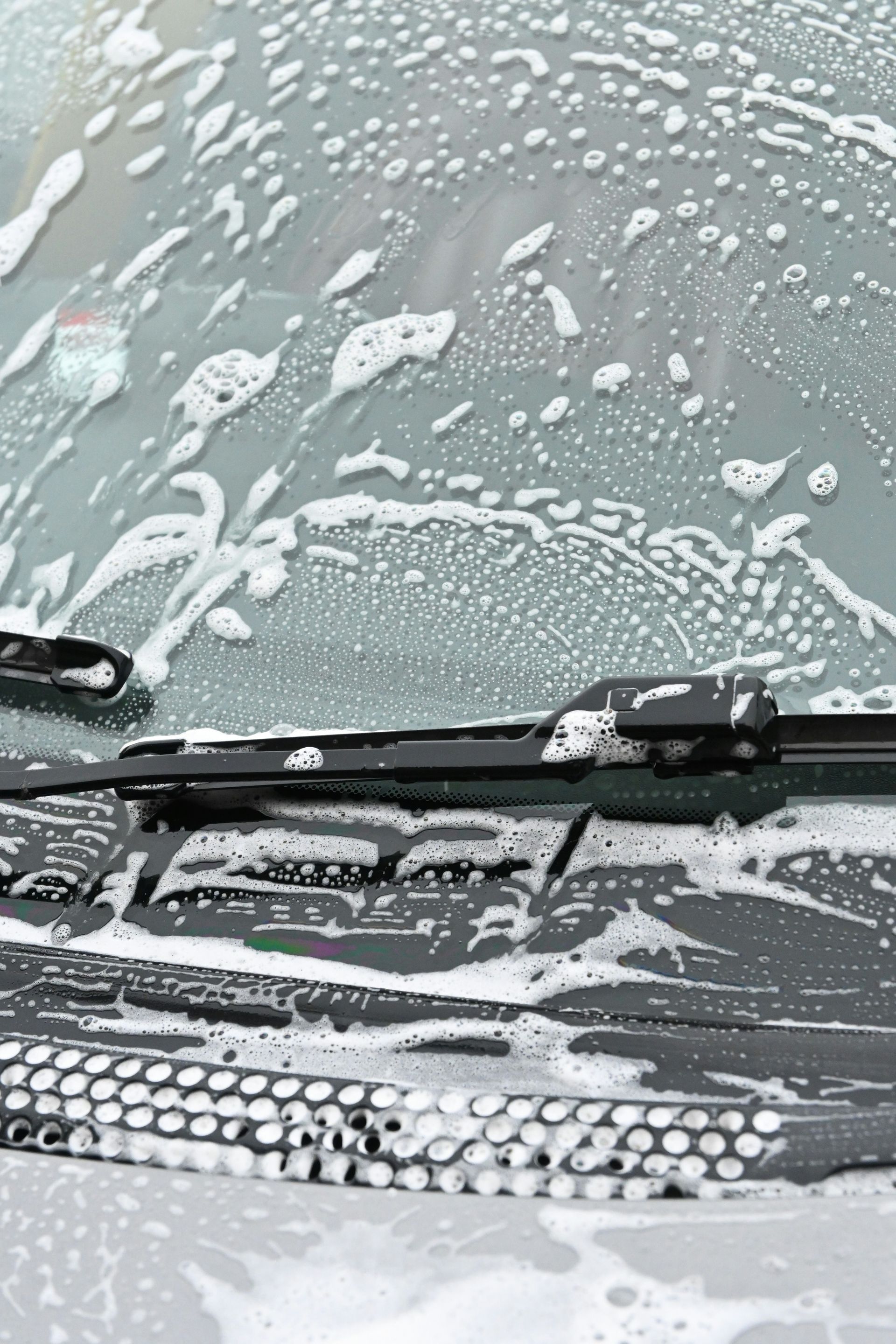 The windshield of a car covered in snow